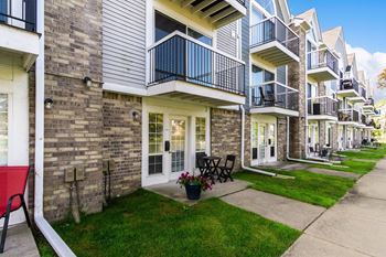 A row of townhouses with balconies and flower pots on the lawns